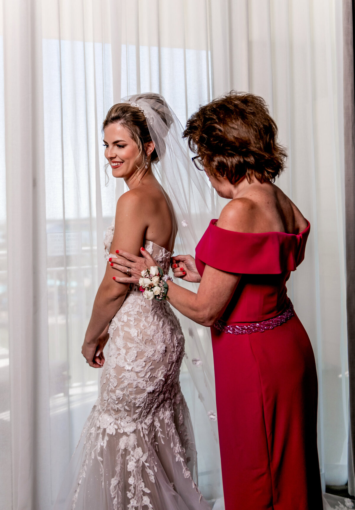 mom putting brides dress on