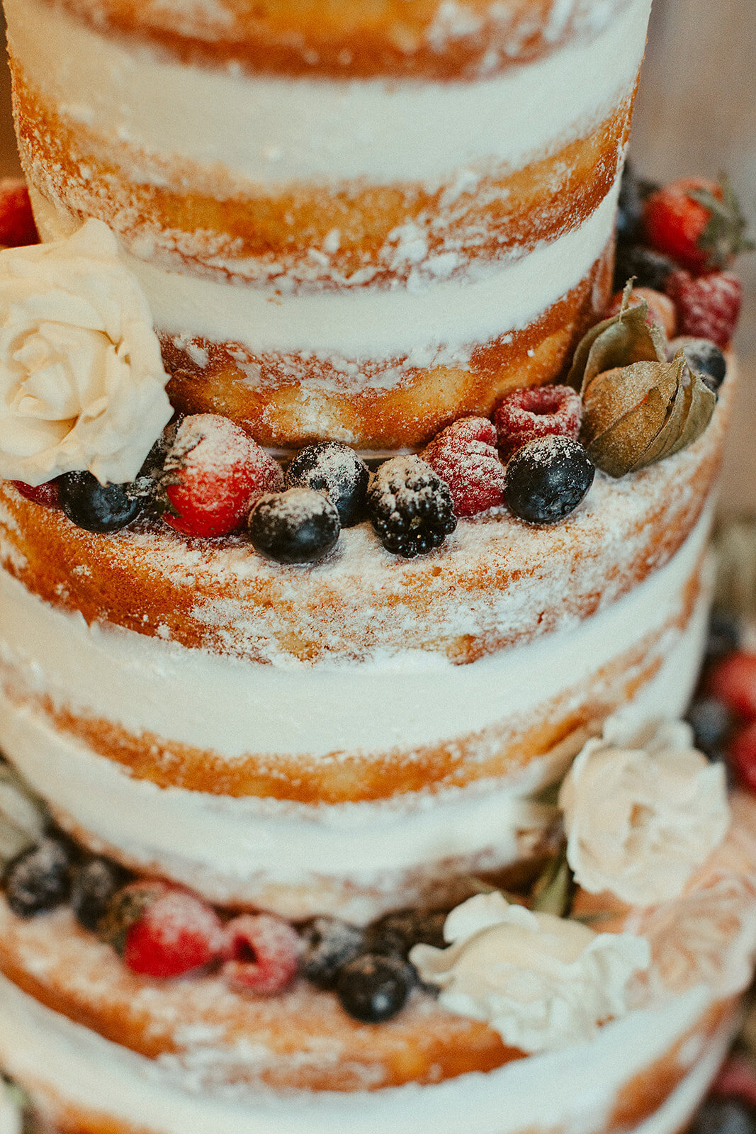 naked wedding cake with raspberries, blueberries and blackberries