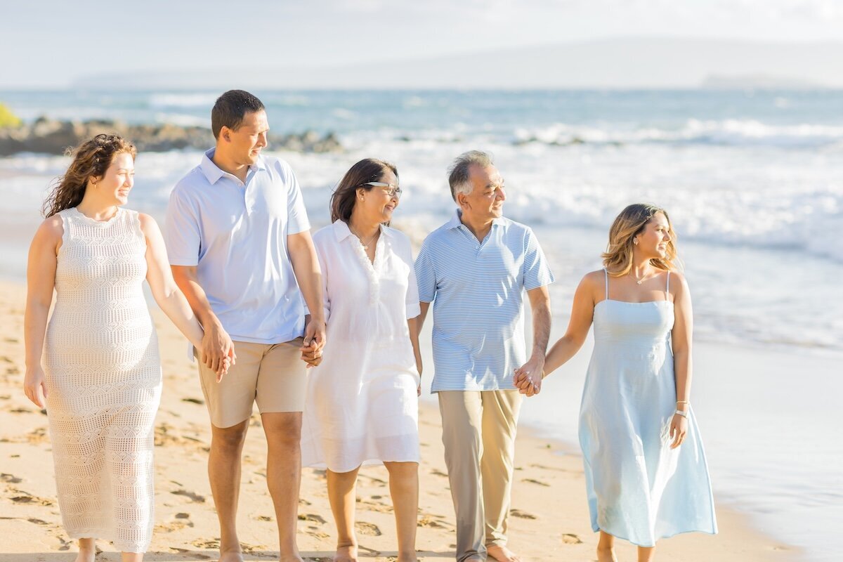This morning portrait has beautiful gold lighting with ocean in the background. Family is walking on White Rock Beach in Maui, Hawaii. 