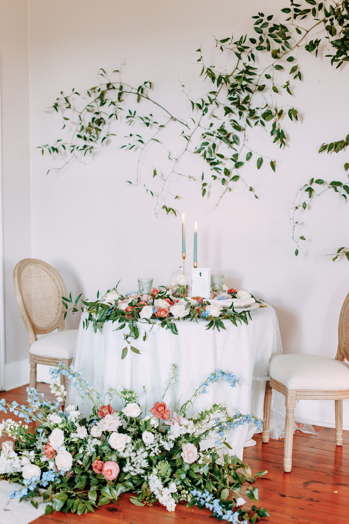 table for 2 with large floral displays and greenery