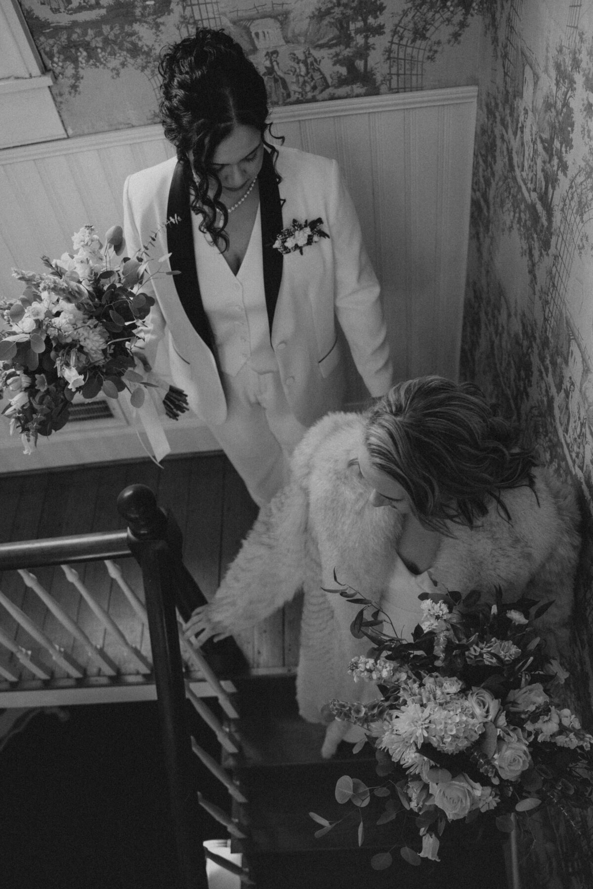Two brides walk down the stairs of a Tennessee home 