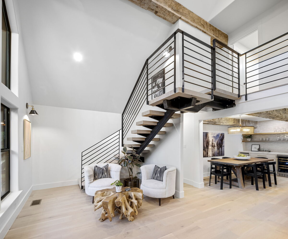 Metal railing wooden stairs in an open plan living room and kitchen