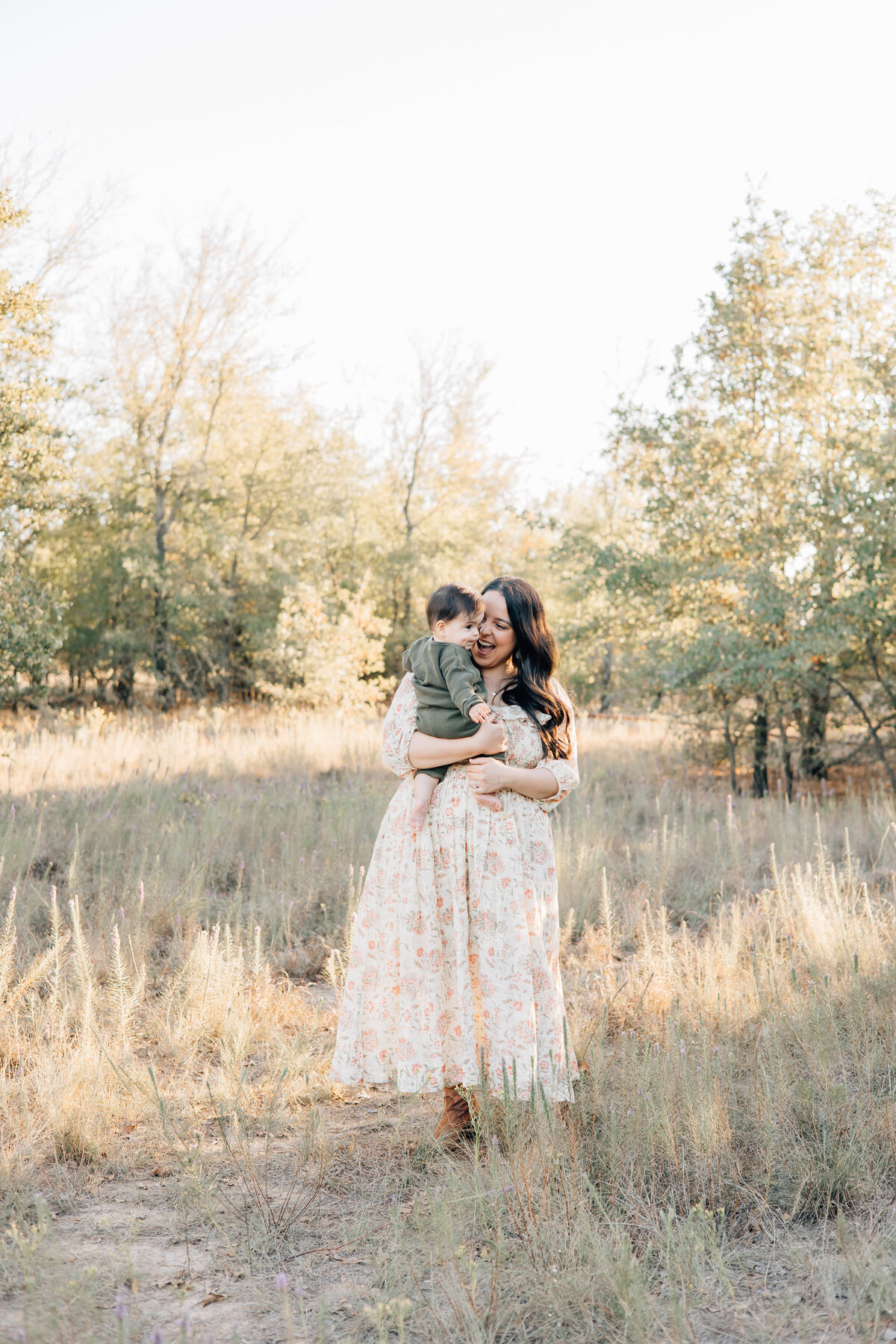 Fall motherhood image with treeline and golden grass during sunset located in Flower Mound, TX