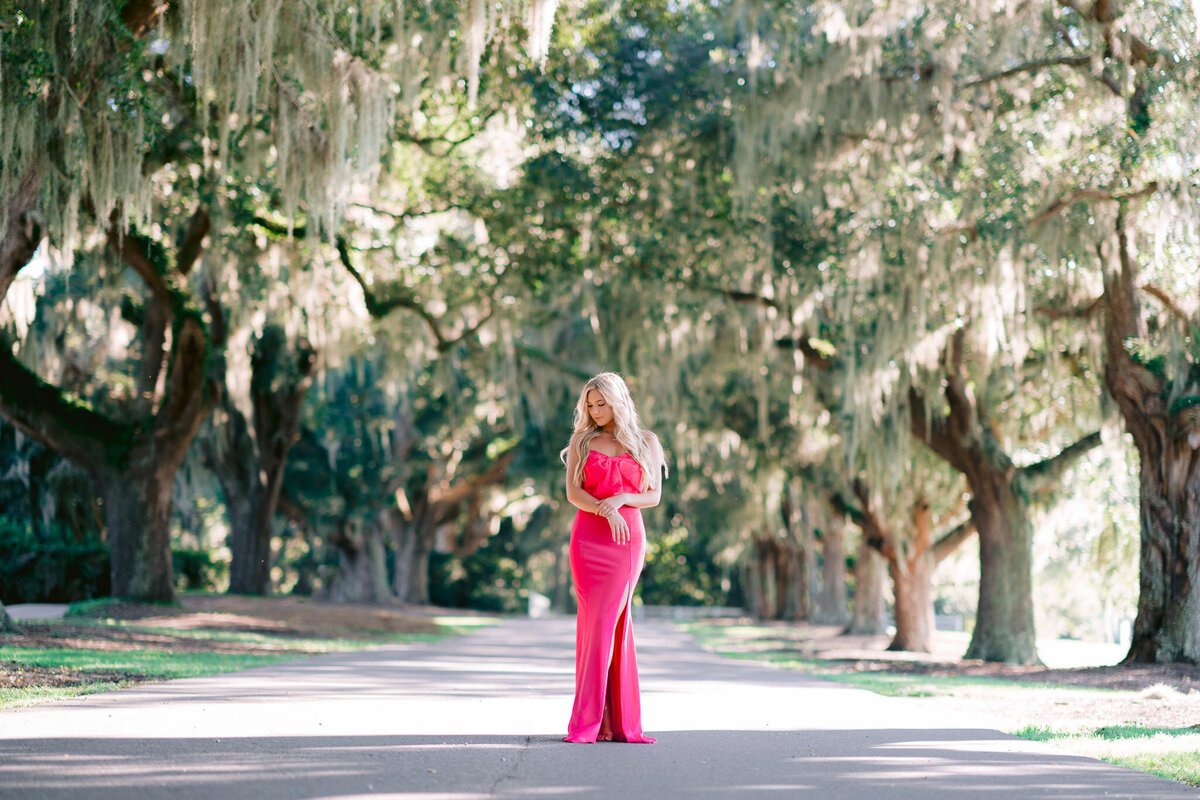 Senior girl in pink dress surrounded by Spanish moss during a photo shoot on Kiawah Island