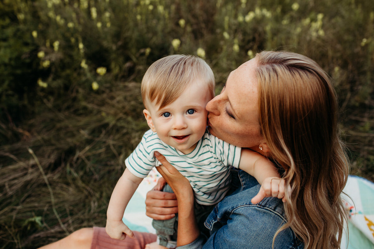 close up of mom kissing baby son on cheek during Toronto summer family photography session