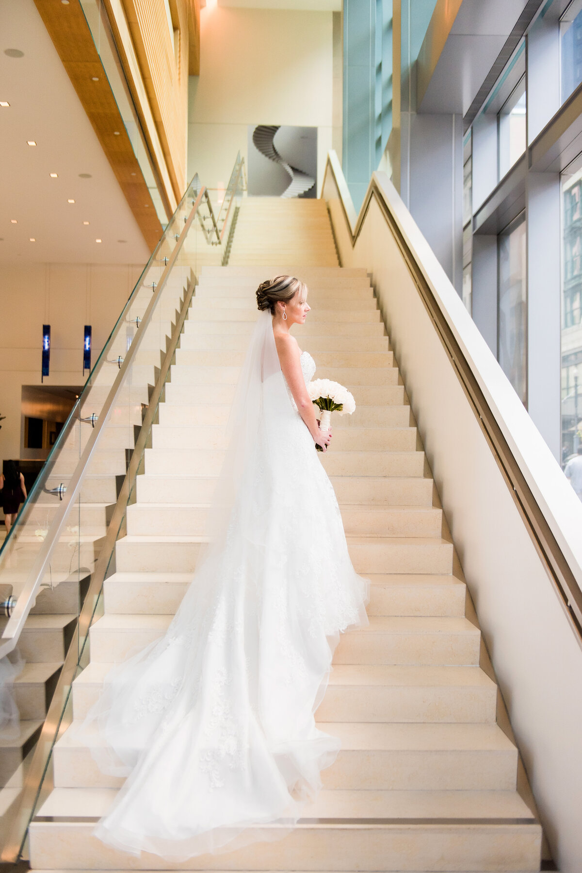 bride on the fairmont hotel stairs in pittsburgh looking out the window