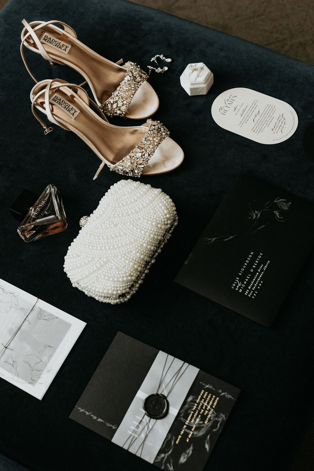 Wedding day bridal accessories including heels, ring, perfume and beaded clutch.