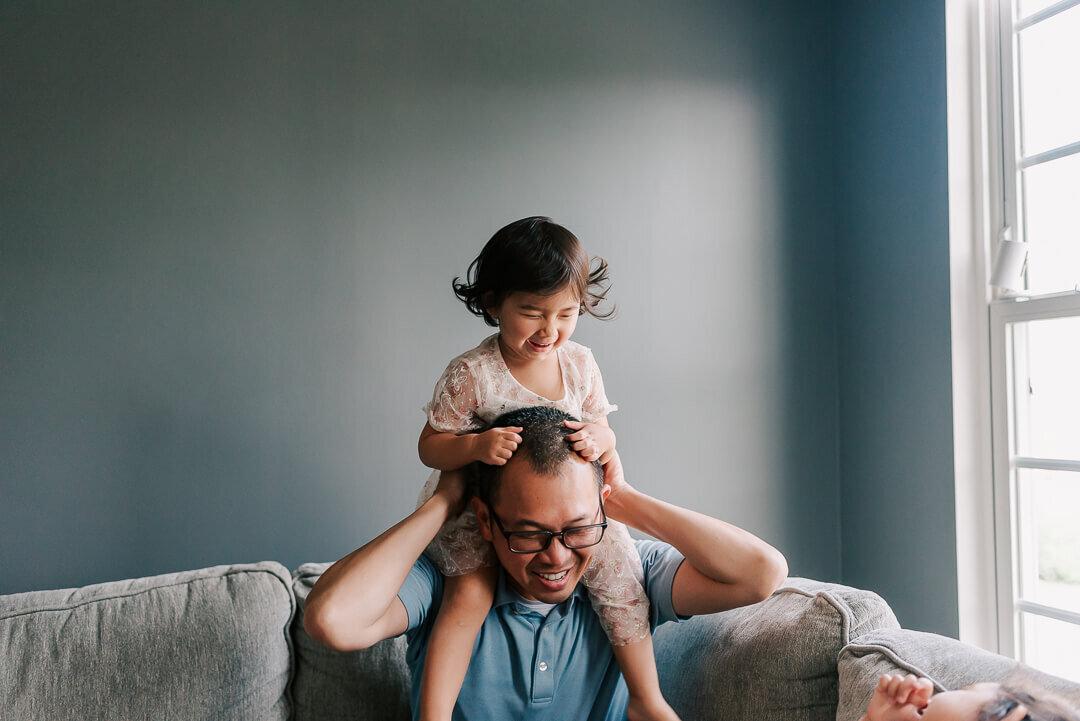 A little 2 year old enjoying a ride on dad's shoulders