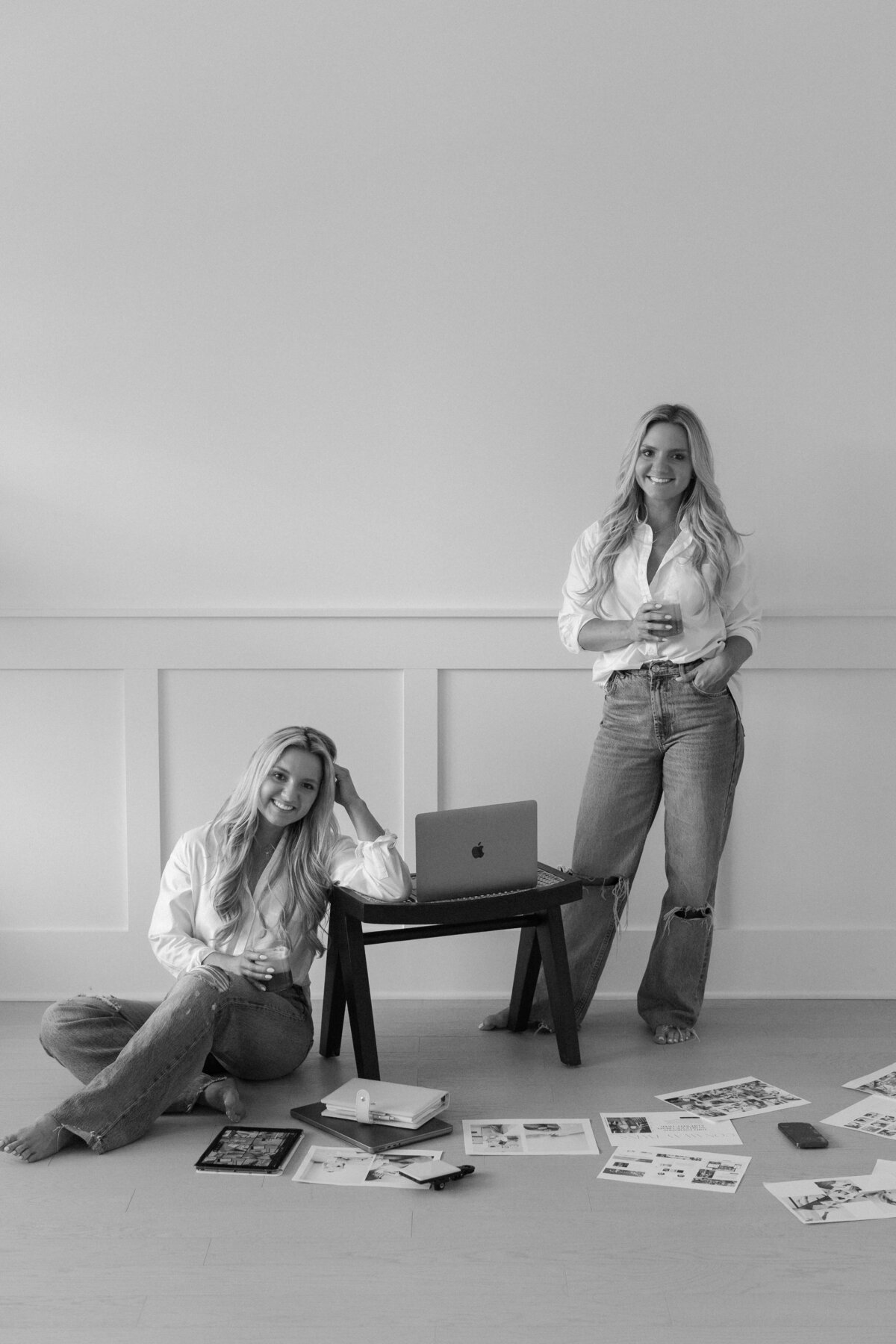 Black and white photo of influencers working with laptops and moodboards, highlighting creative content creation and collaboration.