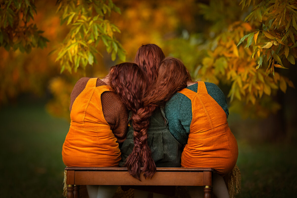 redhead sisters braided their thick long hairs together while wearing Old navy fall color clothes.