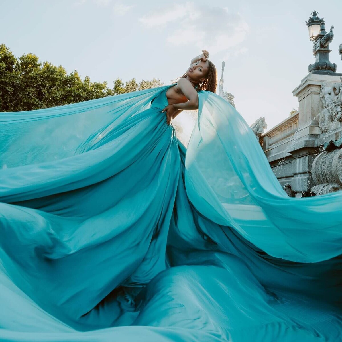 women having a portrait photoshoot in paris wearing a blue flying dress