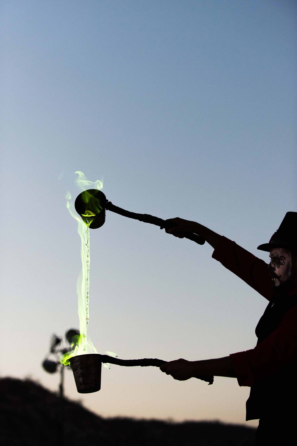 An entertainer pours fire in a bucket for entertainment