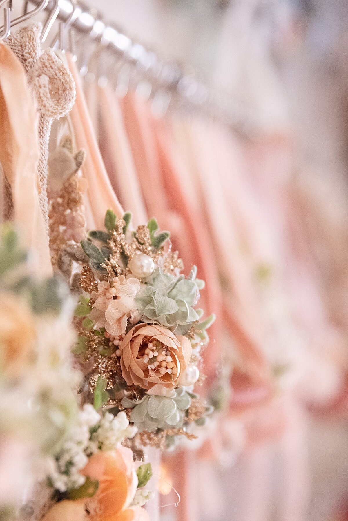 Close-up of hanging newborn photography headband props and accessories arranged on a rack inside a professionally organized studio.