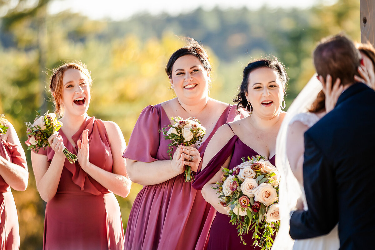 Bridesmaid smiling and laughing in beautiful pink dress at wedding ceremony