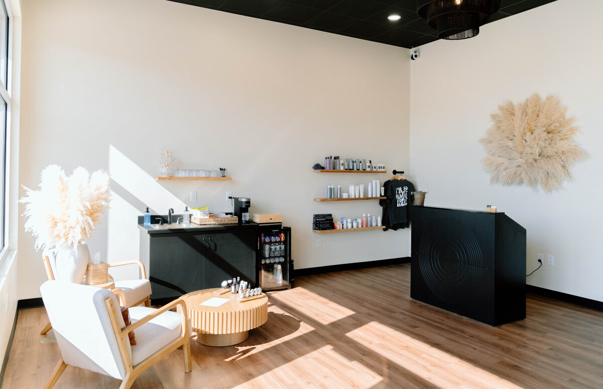 Reception area of Lavender & Ink Studios with modern seating, retail display, and front desk in New Franken, WI