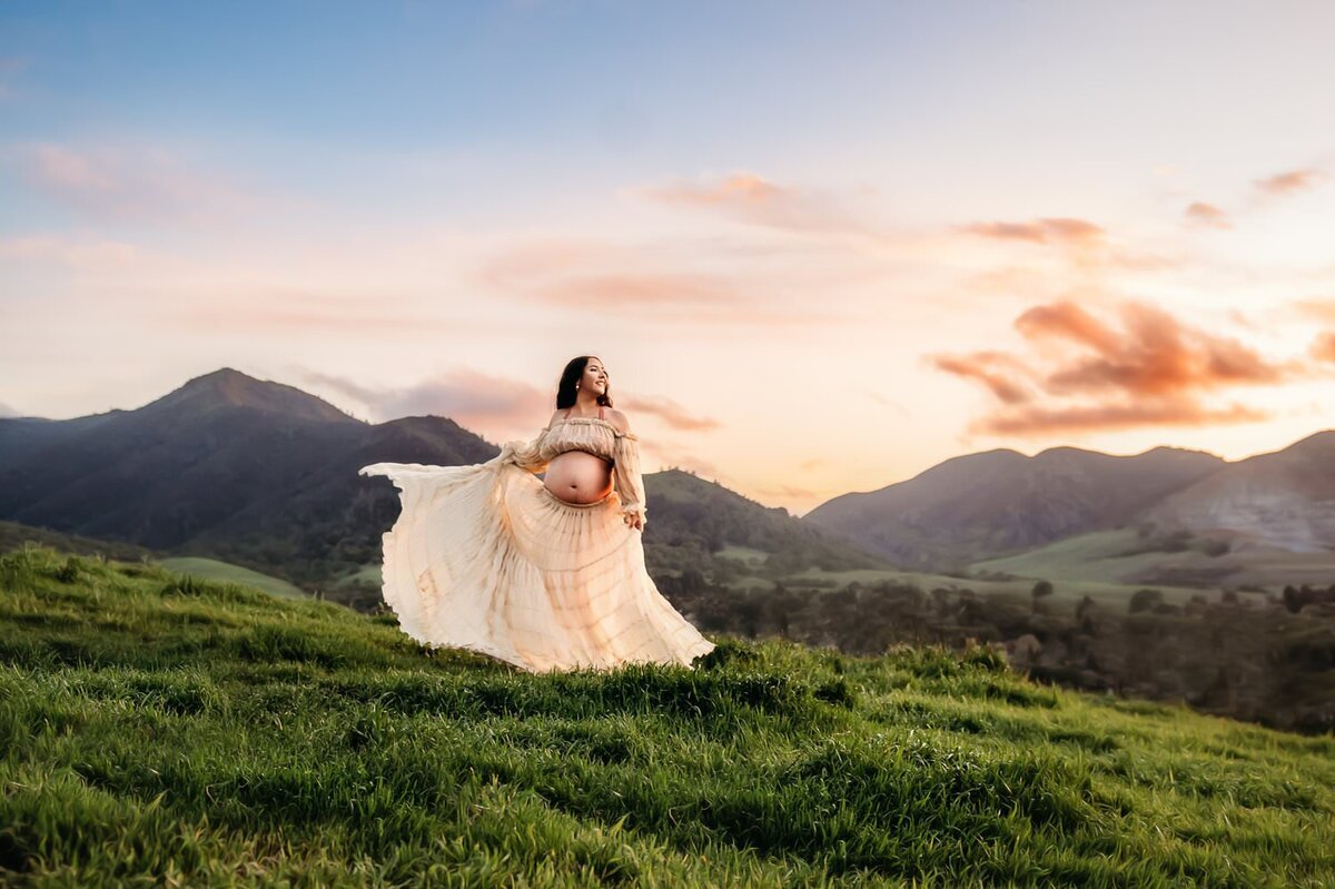 beautiful photo of a pregnant mama dancing and twirling in the hills near mt diablo.