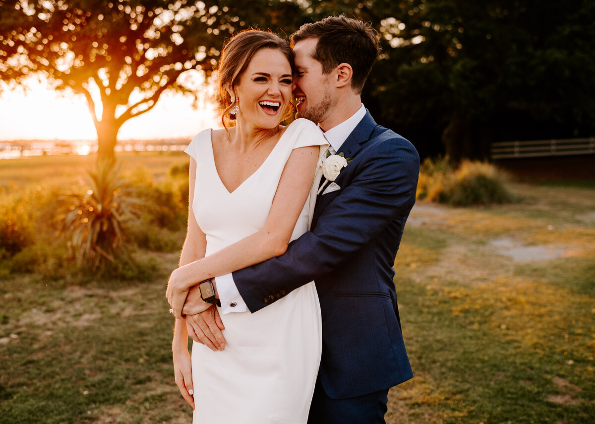 man behind woman hugging her and making her laugh