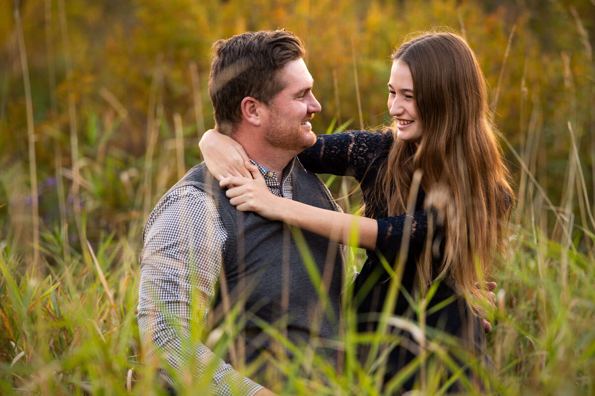 family photos in Ottawa of a teenage daughter hugging her father during a golden hour sunset session