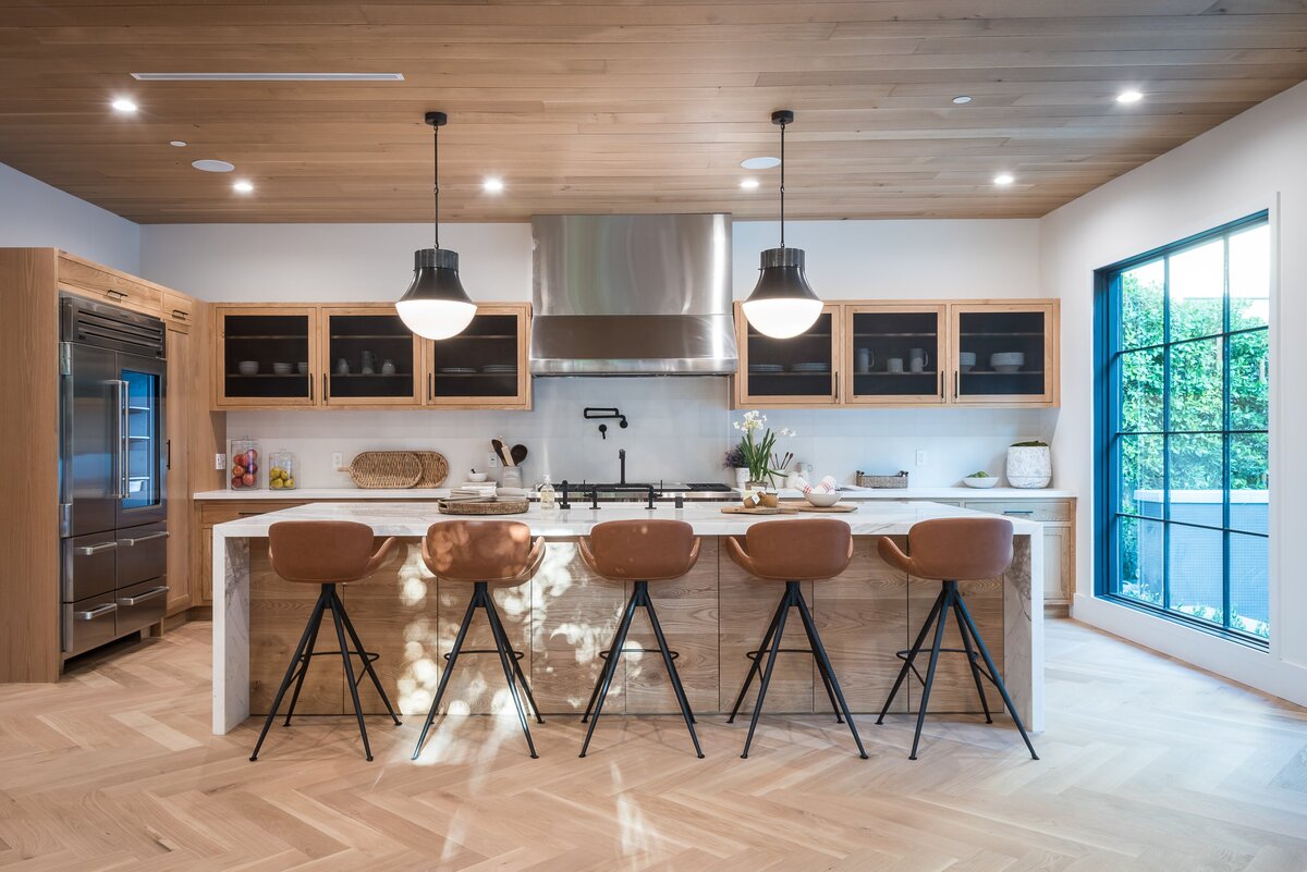 Modern, warm kitchen design. Light wood cabinets and black details.