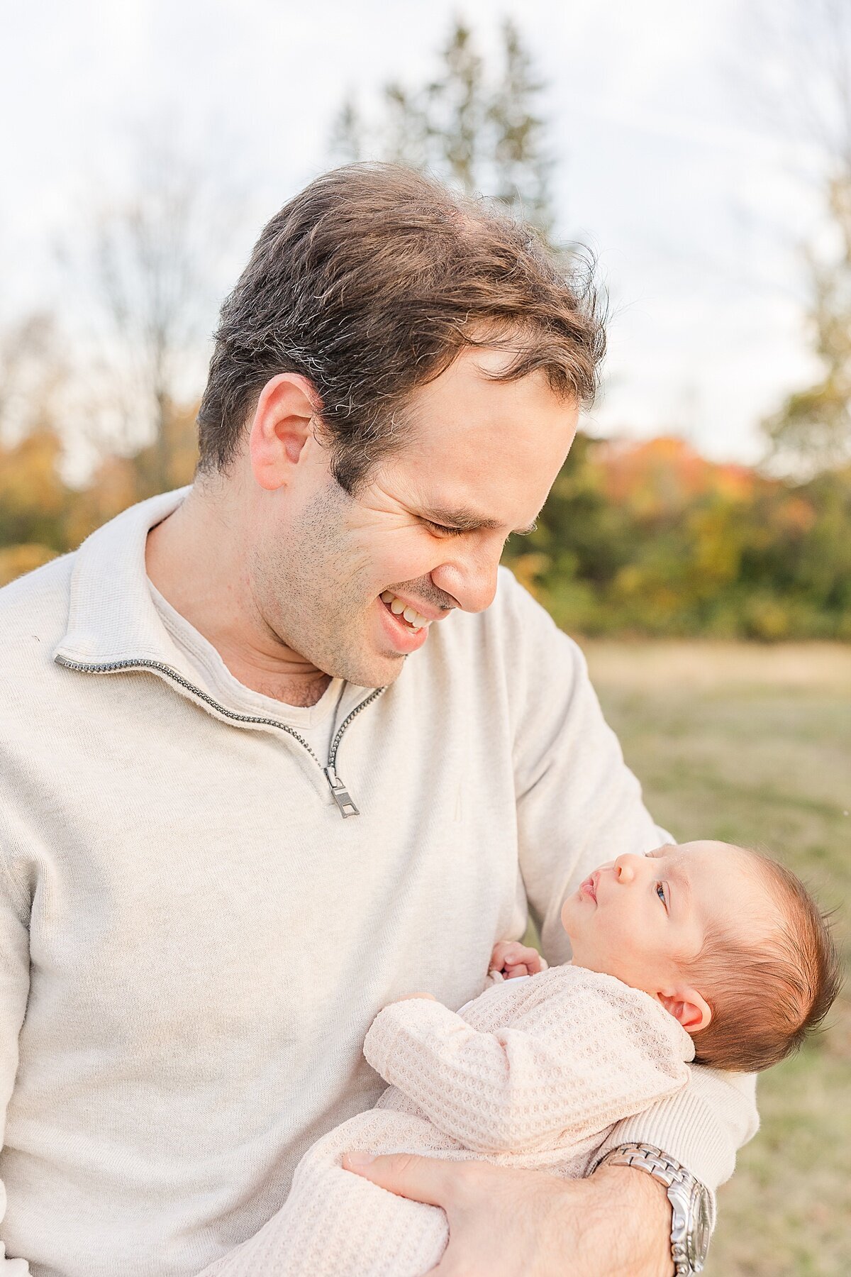 dad holds baby  during outdoor newborn photo session with Sara Sniderman Photography in Natick Massachusetts