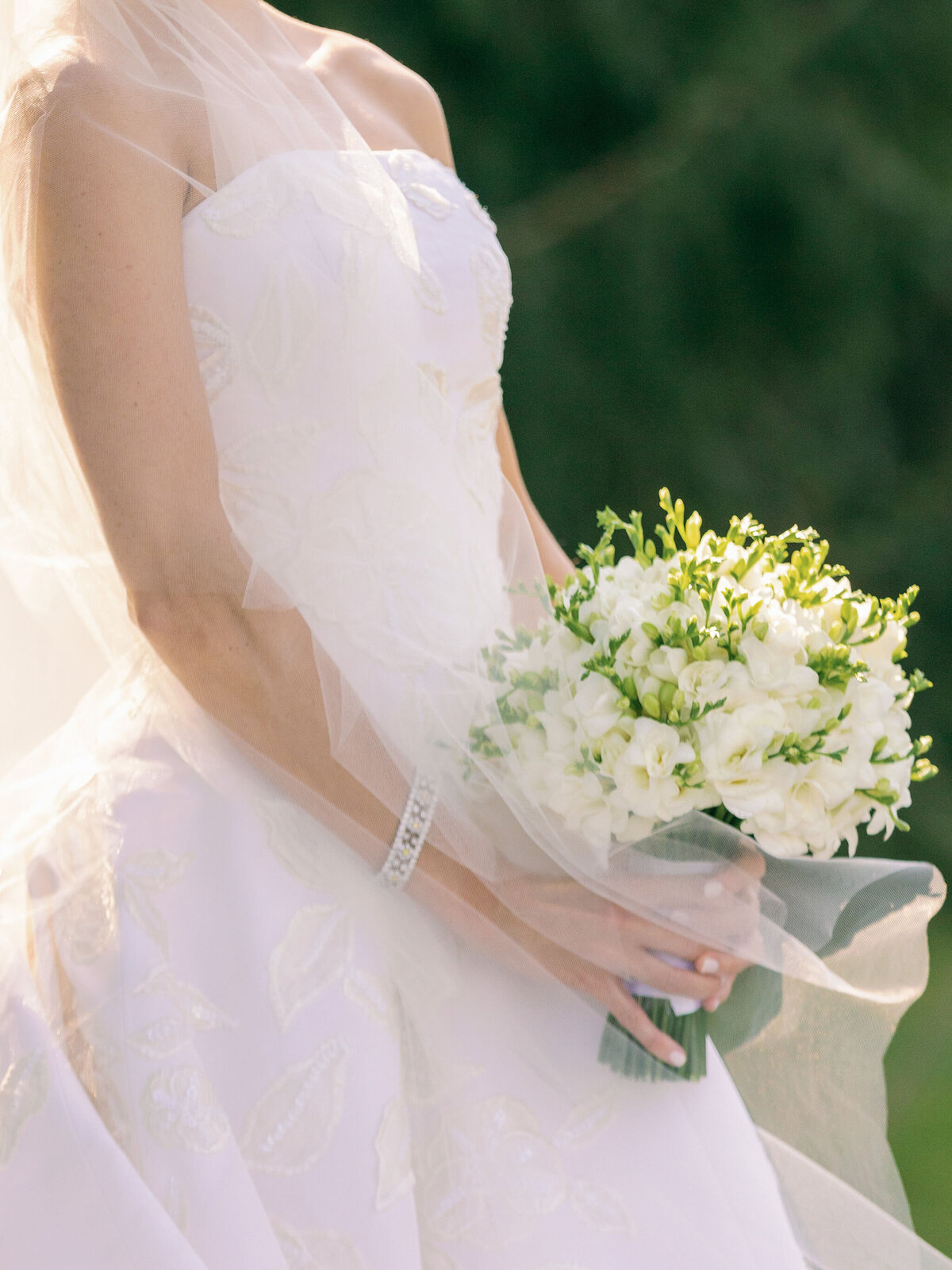 Up close photo of the bride holding her bouquet of flowers. 