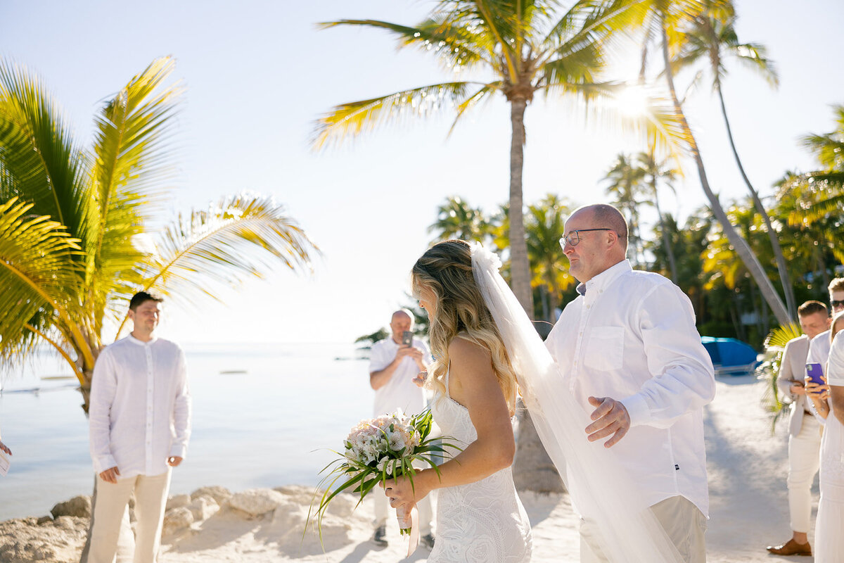 Laura walking down the aisle with her father at her stunning beachfront wedding at Cheeca Lodge Resort in Miami.