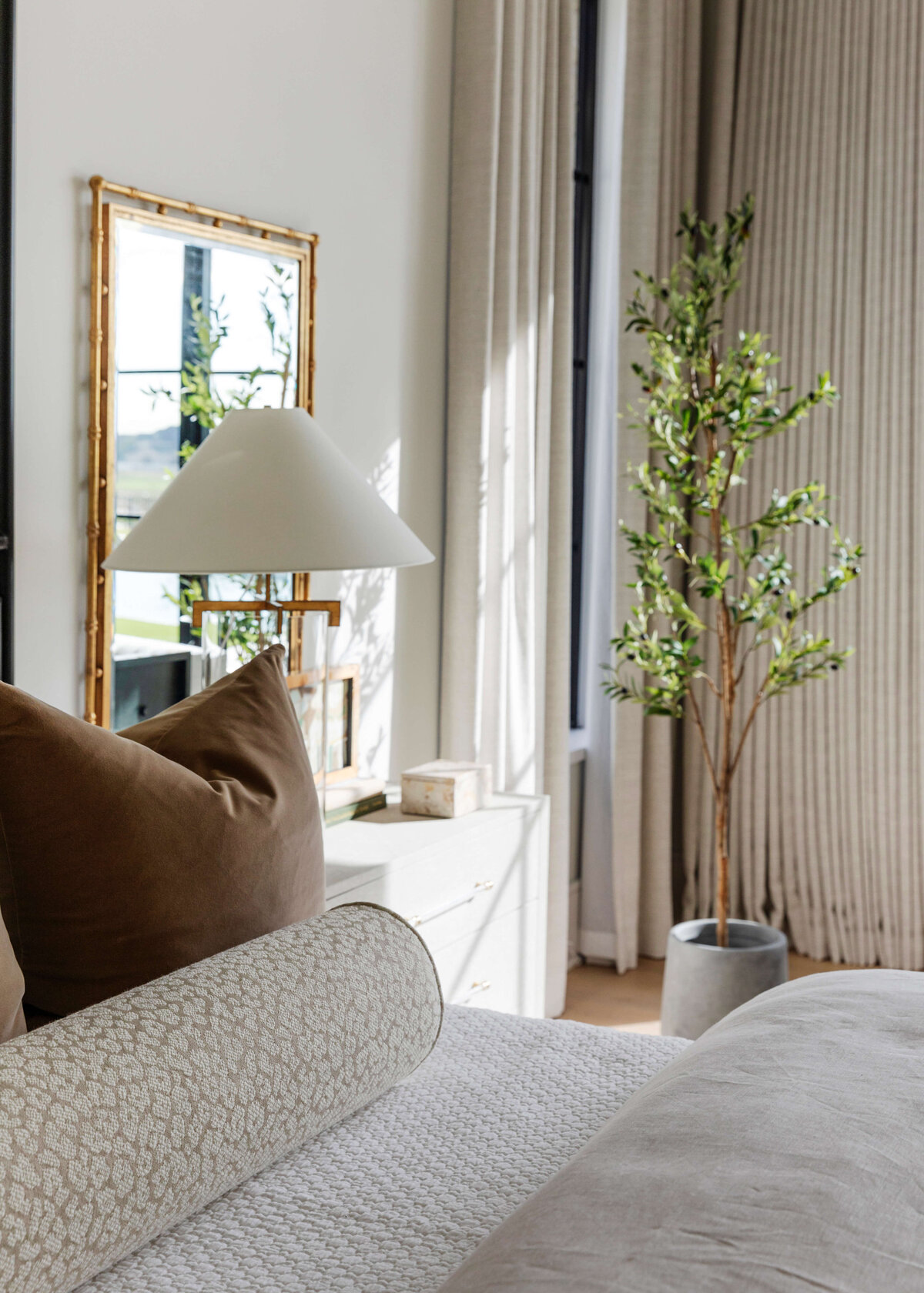 oyster creek studios hughes plant in bedroom with brown pillows and side table