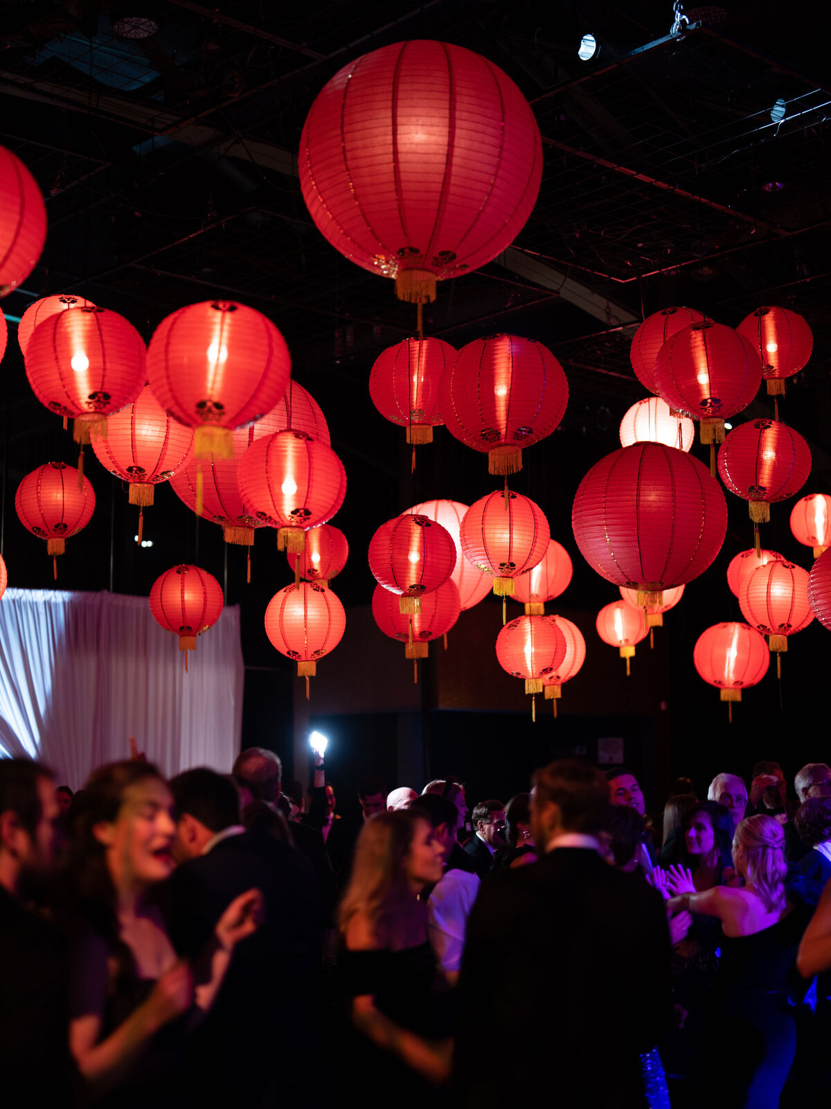 A stunning display of red lanterns hanging from the ceiling, casting a warm and festive glow over the space.