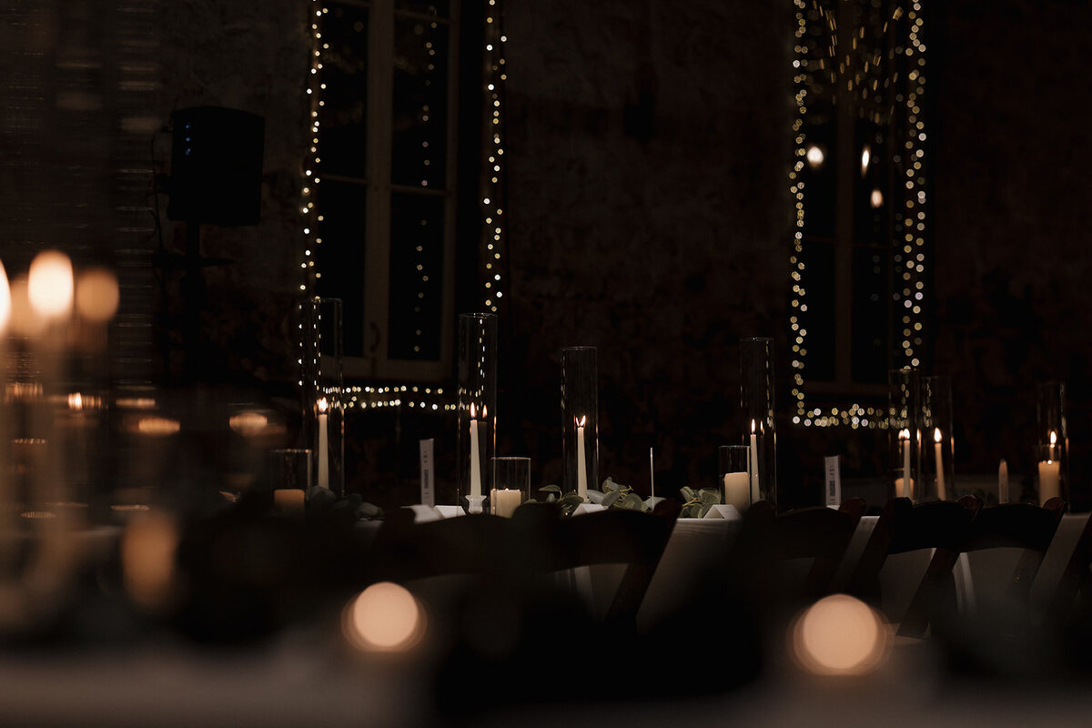 Editorial wedding photographer capturing the sophisticated ambiance of an intimate wedding reception illuminated by candlelight.