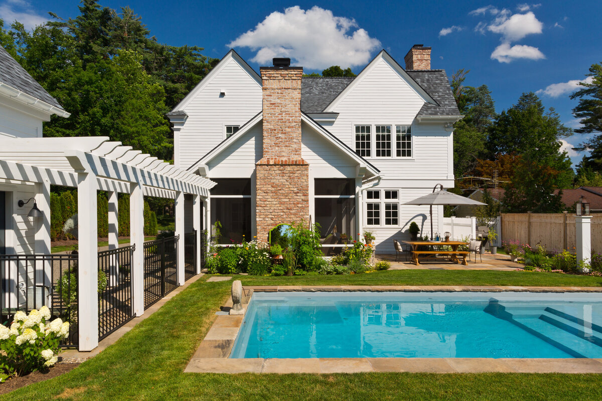 outside view of white house green manicured lawn with large pool