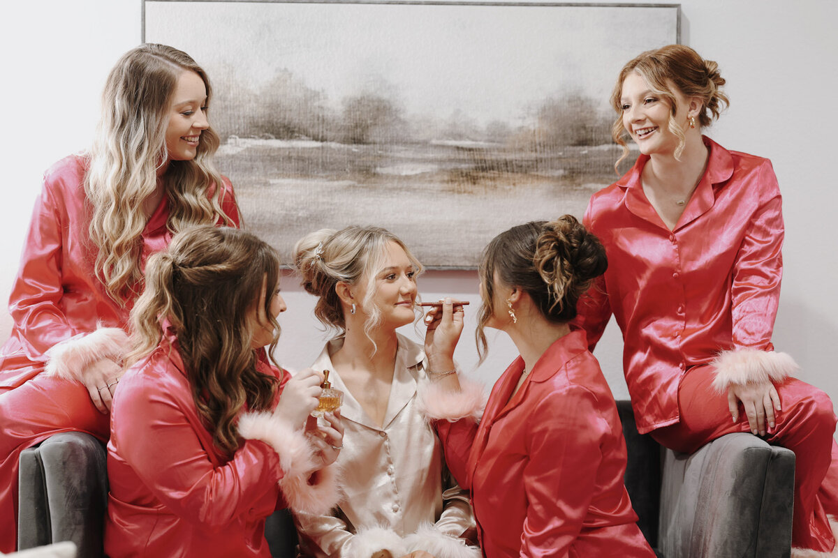 Bride and the bridesmaids putting on makeup in the Bridal Suite at The Rosewood Venue in Mount Vernon, Texas