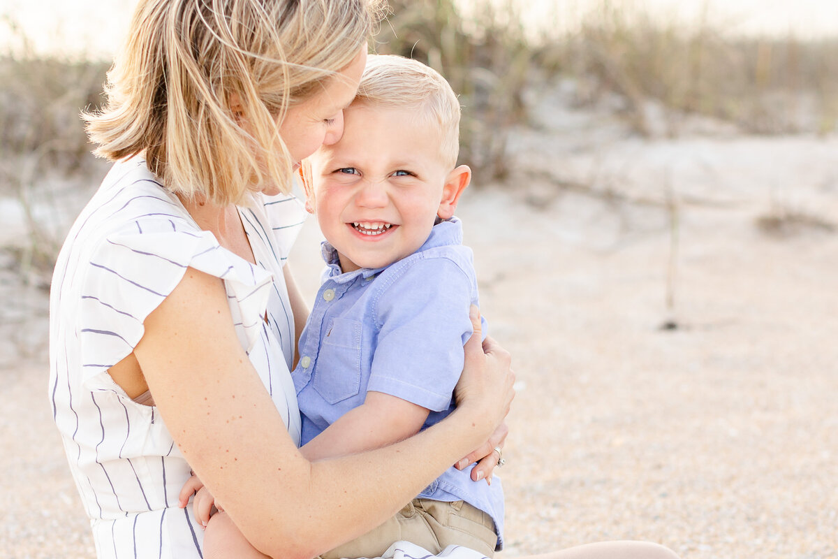 Boy smiles at the camera with his mom during a mini session in Jacksonville FL