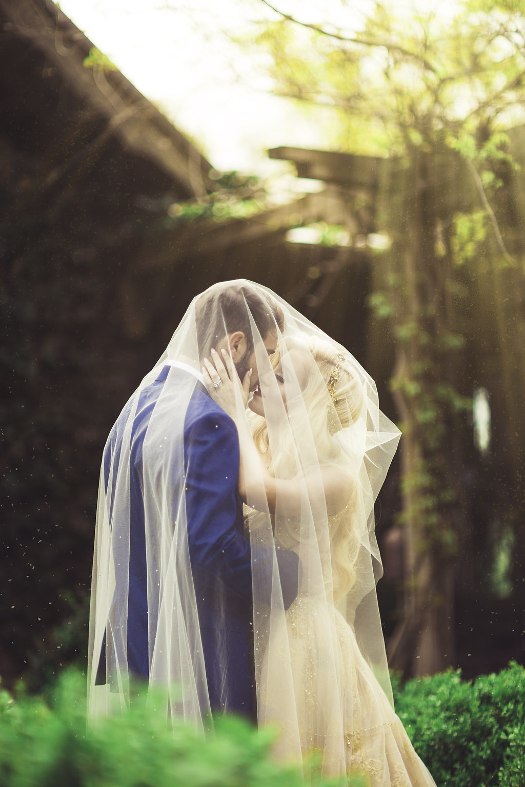 Wedding Photograph Of Bride and Groom Kissing While Covered in Bride's Veil Los Angeles