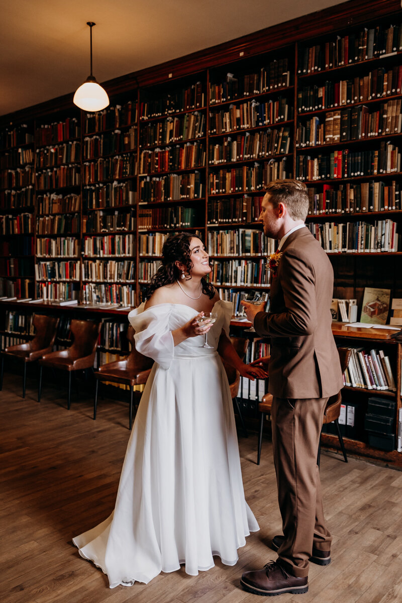 Bride and groom at The Leeds Library drinking champagne