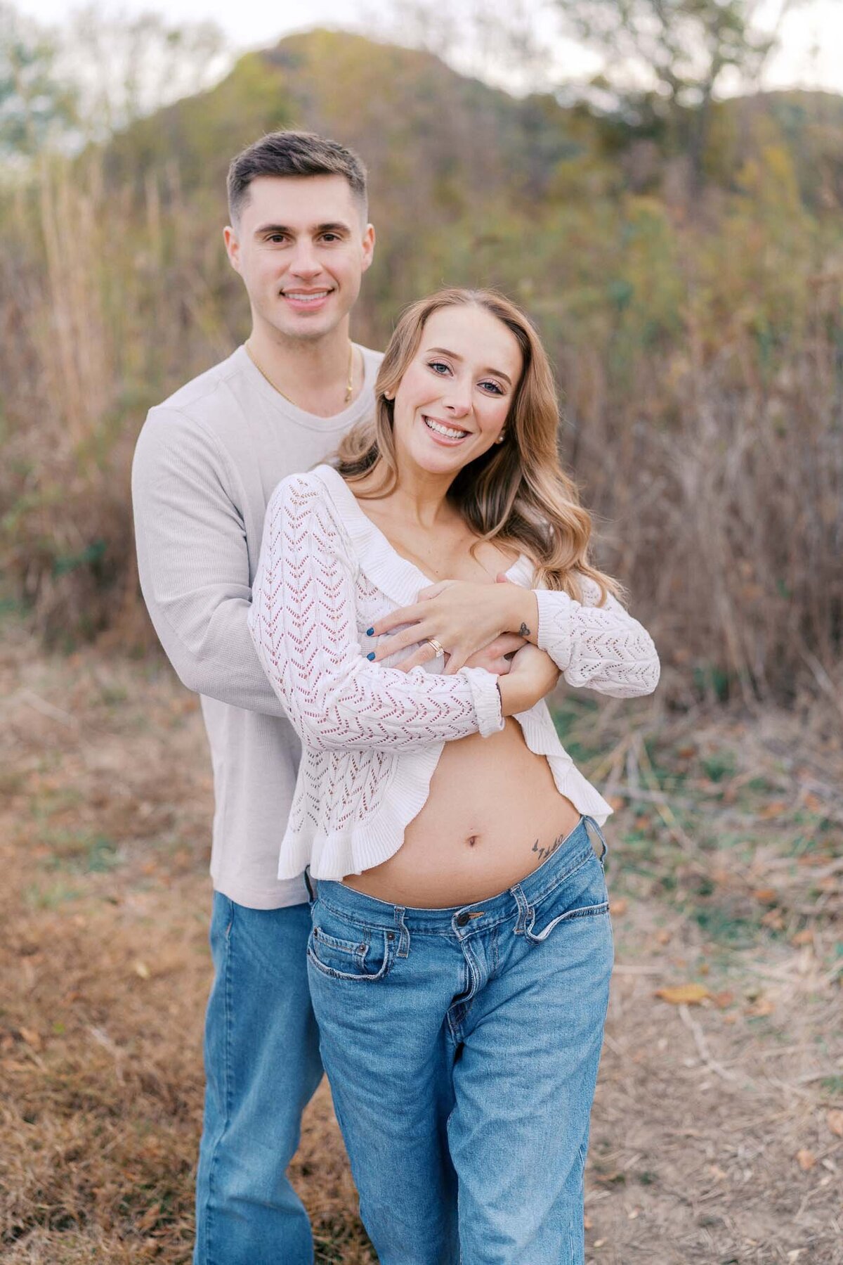 pregnant wife hugs husband in knoxville tennessee field