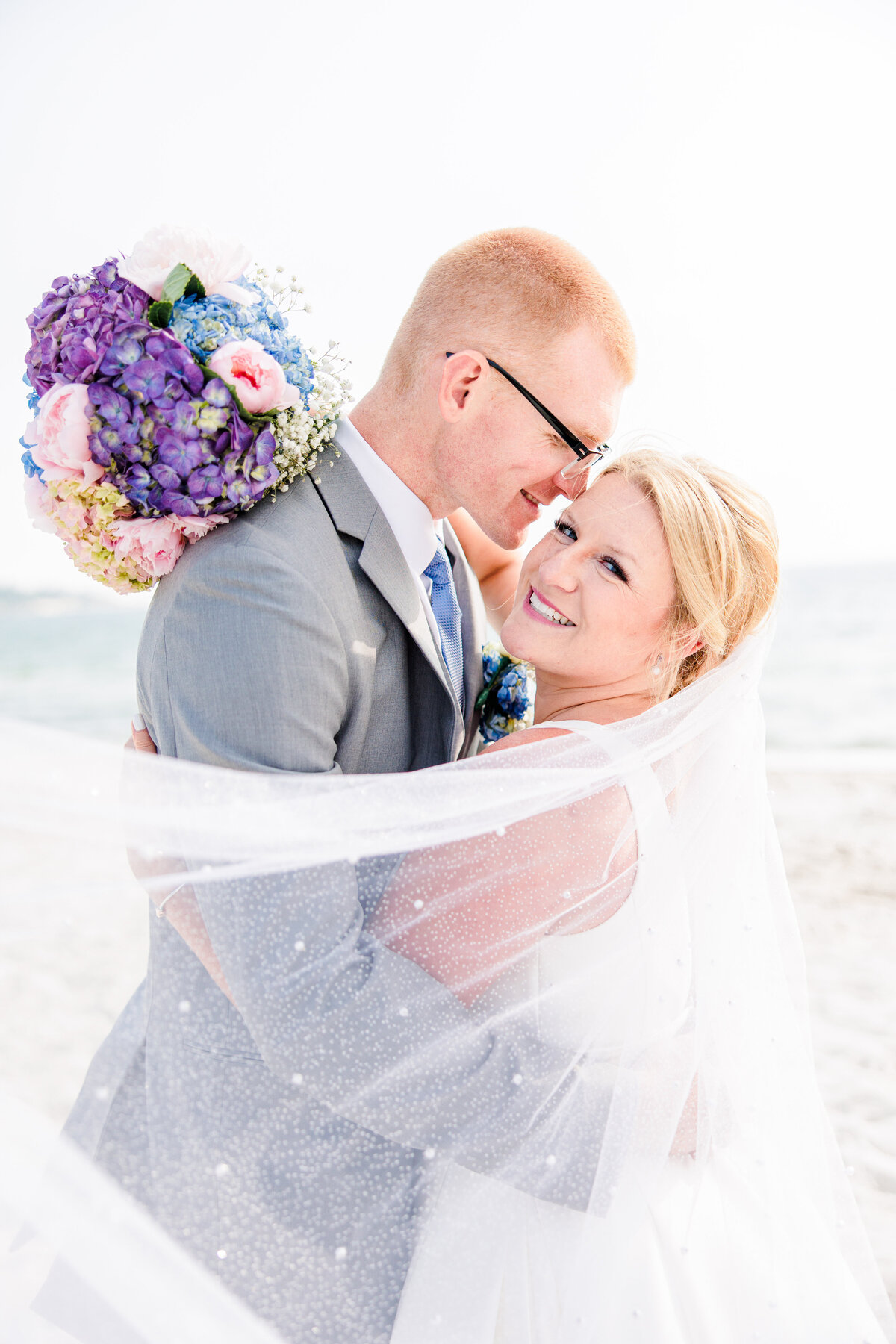 A groom hugging and snuggling his bride representing Cape Cod beach wedding photos