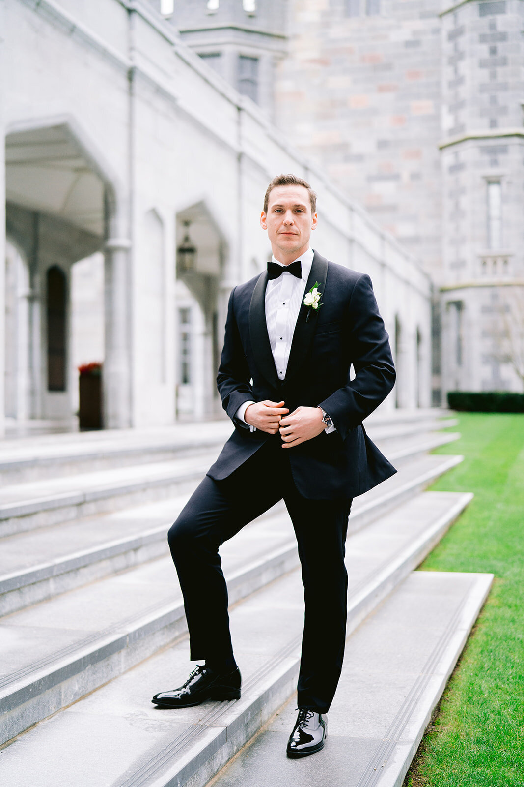 A fine art wedding photograph of the groom looking towards the camera in a Tuxedo outside adare manor