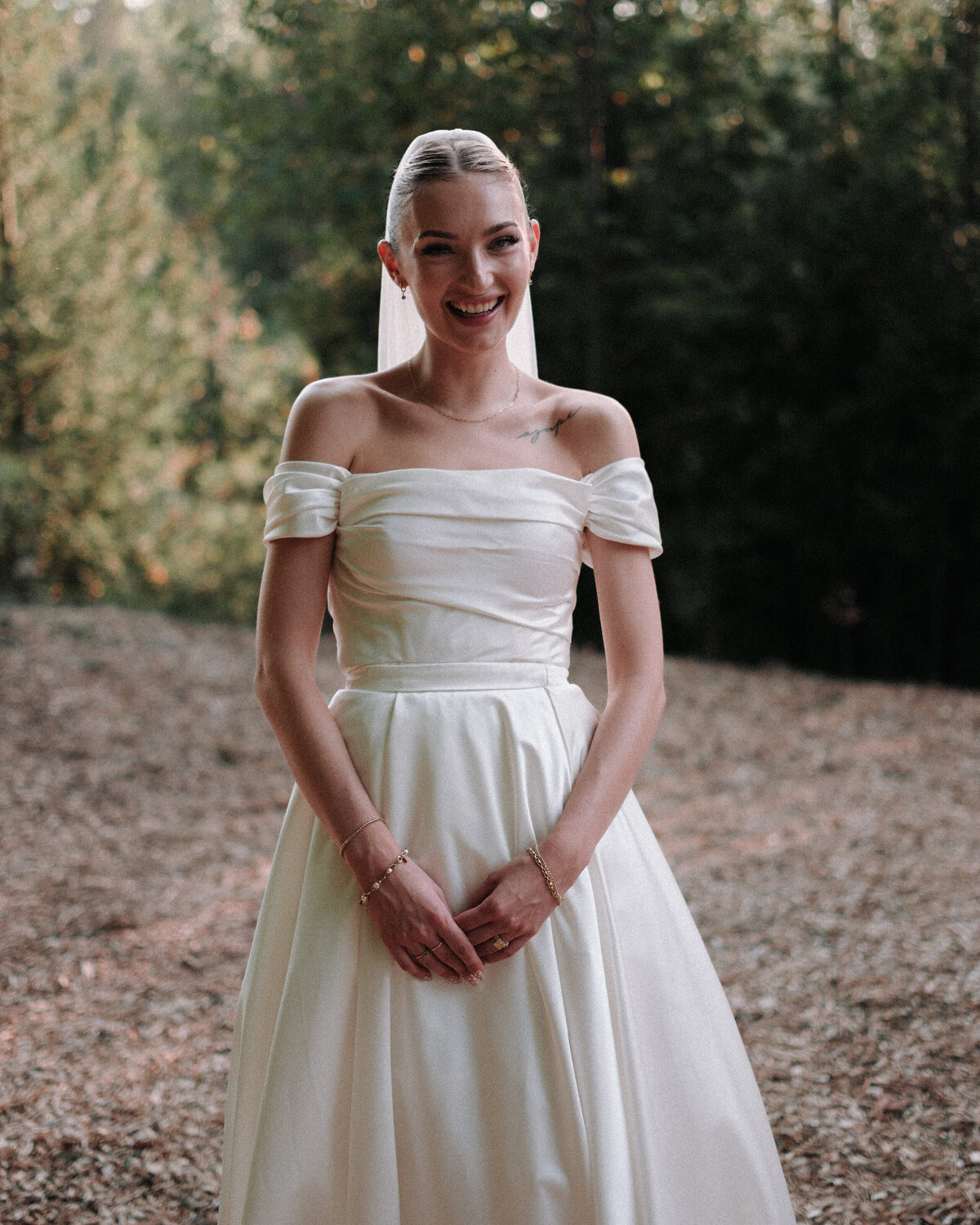 Bride stands in nature smiling from ear to ear
