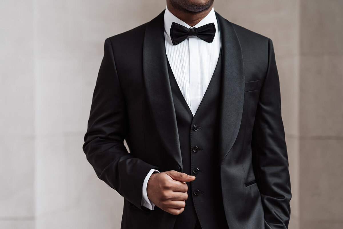 closeup of a groom wearing a black-tie wedding suit waiting for his bride outside the marylebone town hall in London for an intimate wedding ceremony
