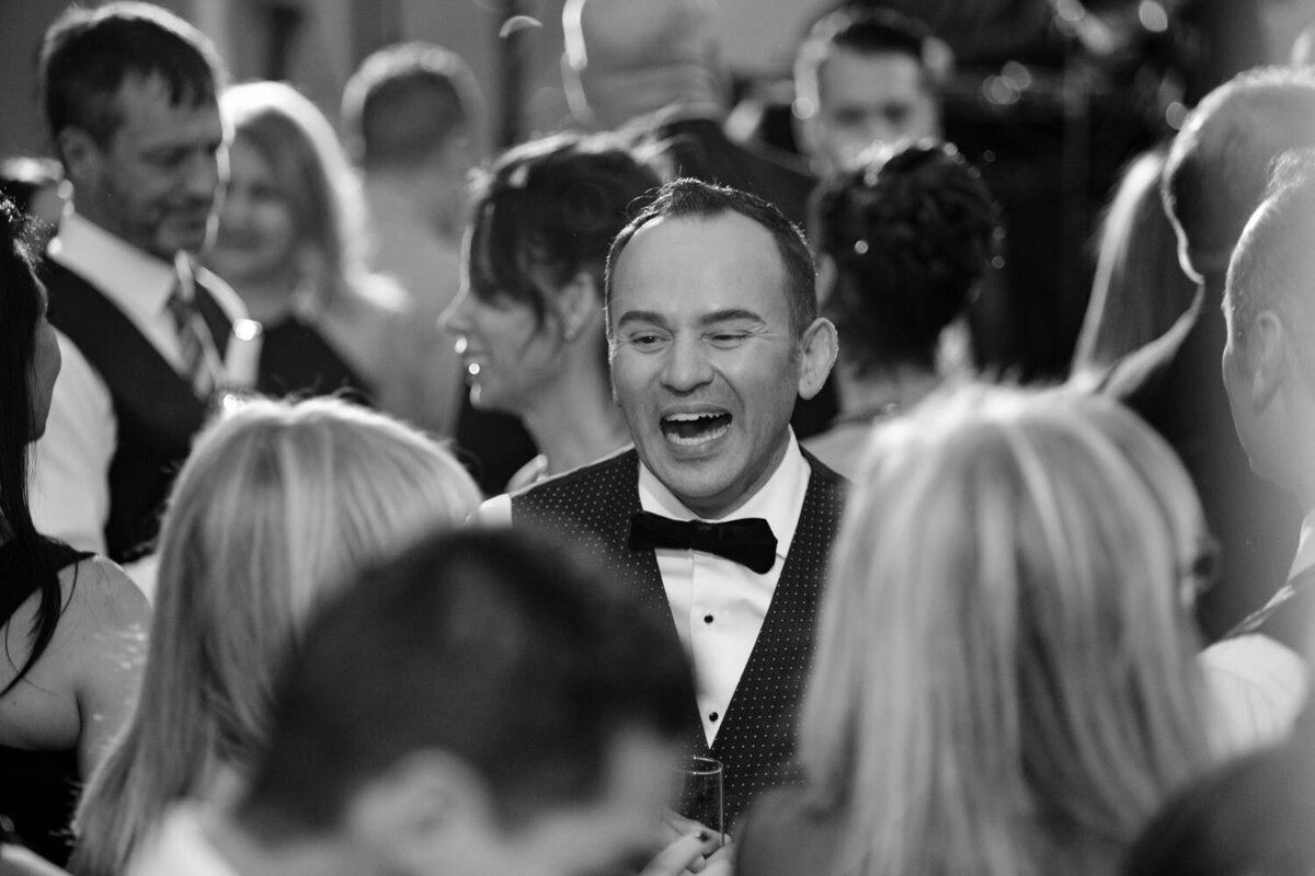 A black and white photo of people smiling on a dance floor