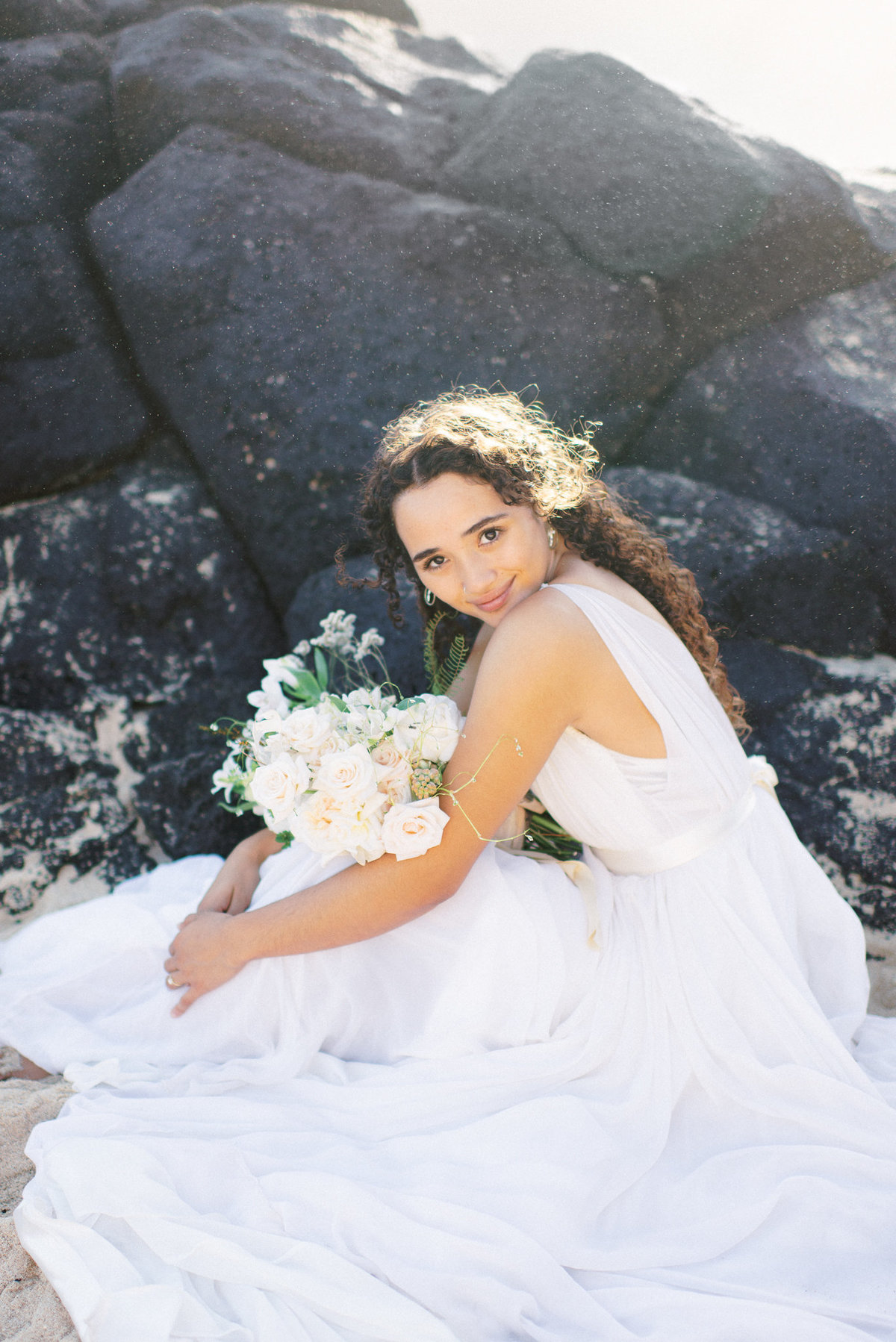 Hawaii bride by black rocks