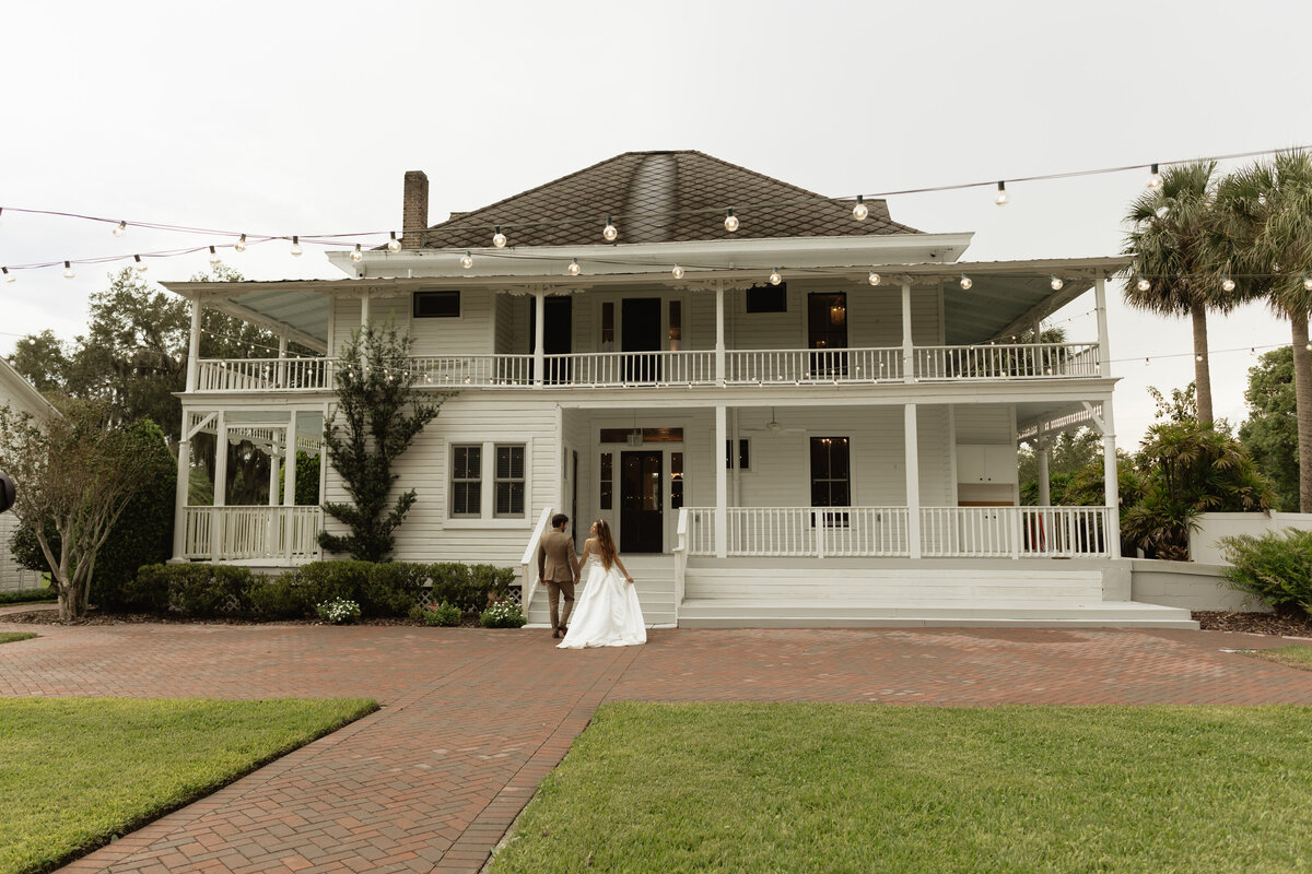 Elegant outdoor wedding surrounded by tropical greenery and historic charm at The Palm Mansion