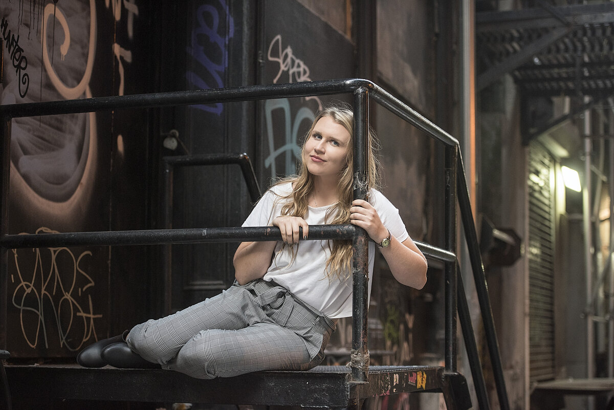 A person sitting on a platform leaning against the railing.