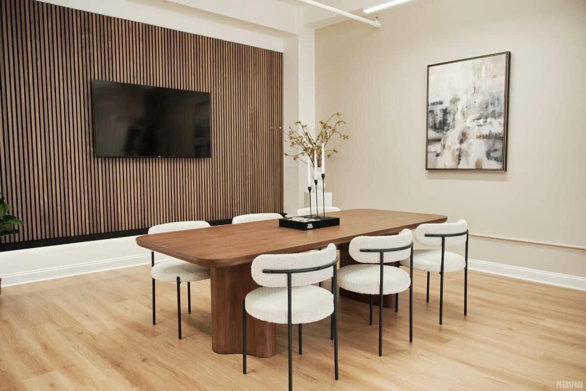 NYC brand photography meeting space with wood conference table, modern chairs, and textured wall design.