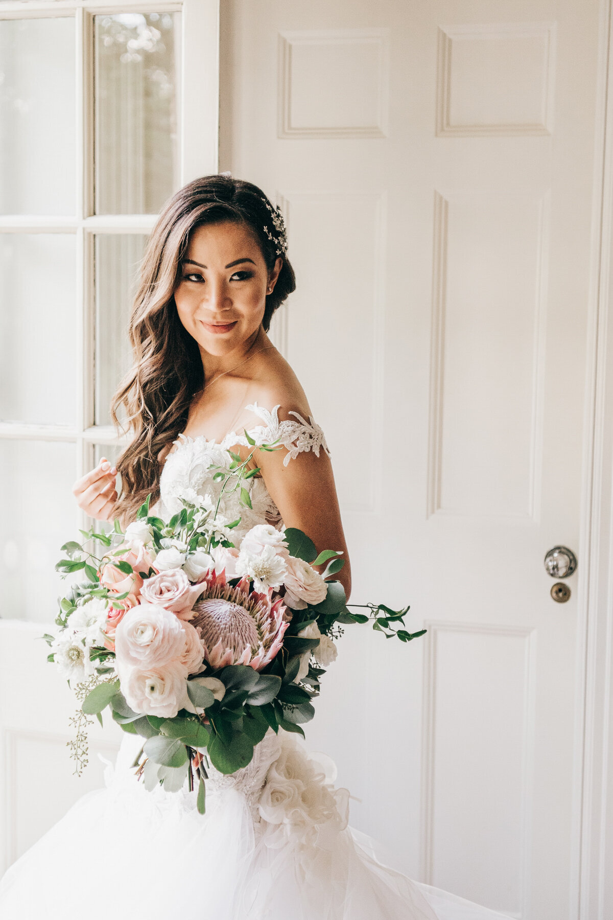 Glamorous portrait of bride holding pink and white bouquet