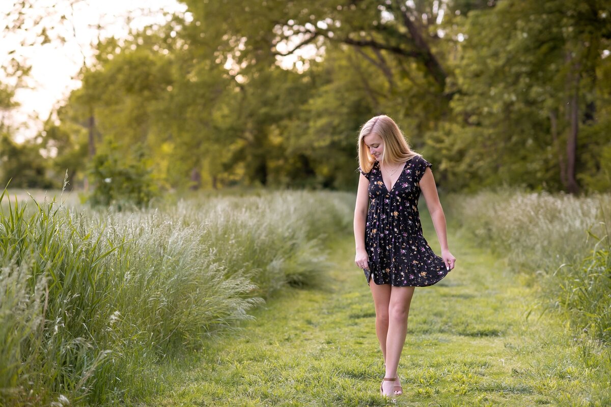 senior walking in field wearing dress