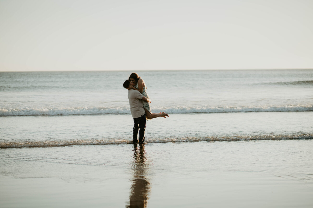Couple kissing each other in the ocean at the Oregon coast during engagement session