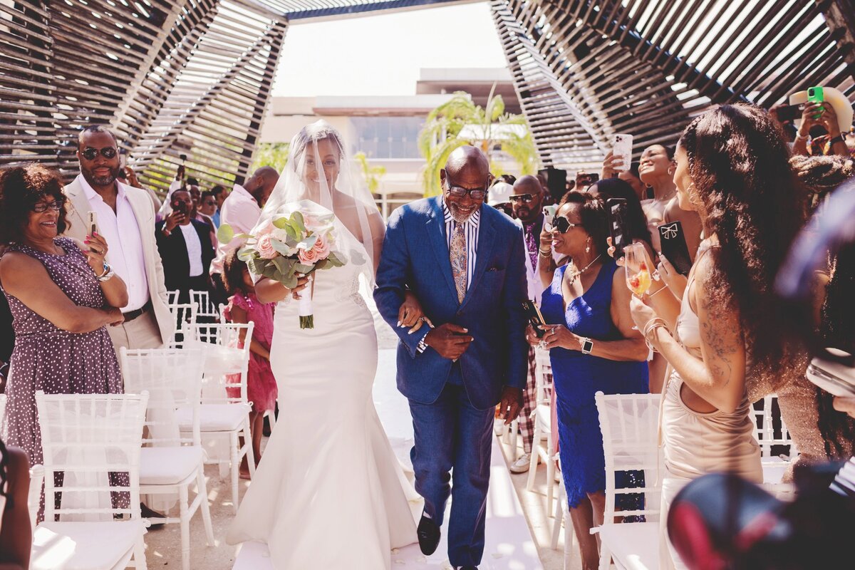 Bride walking down aisle with father at Cancun wedding