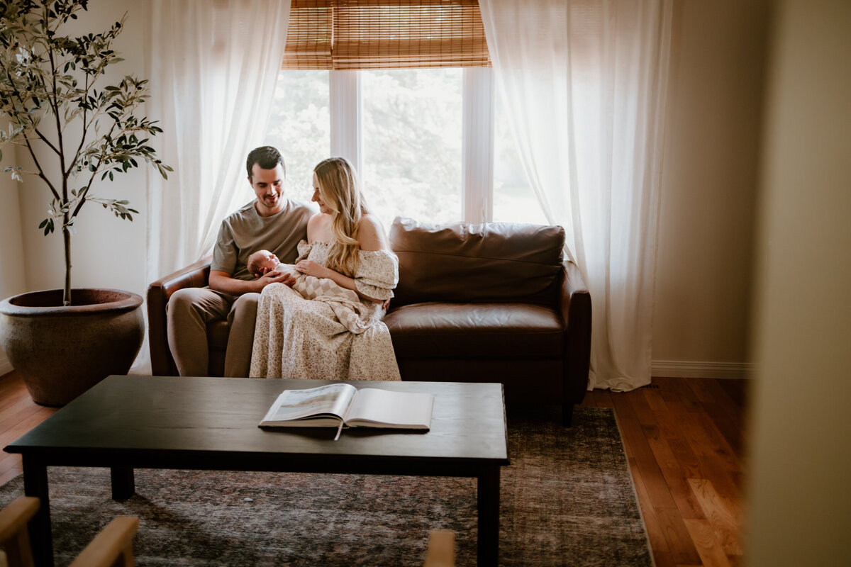 Parents holding newborn on couch