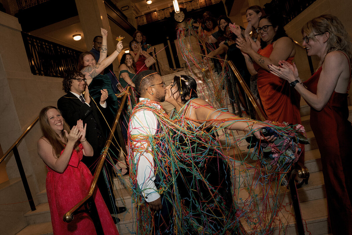 newlyweds send off streamers wedding guests cheering and clapping